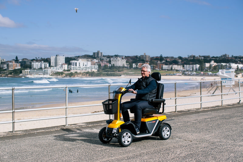 Old man riding Pride Mobility Australia Black Gold Scooter